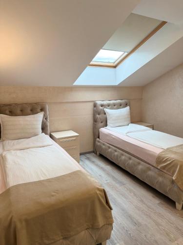 a bedroom with two beds and a skylight at Villa Moste Ljubljana - Modern apartments with Pool, EV station & free parking in Ljubljana