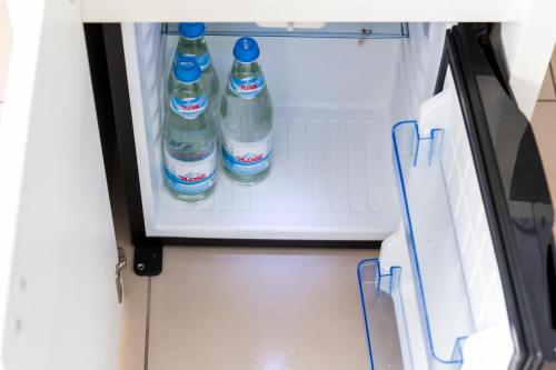 two bottles of water sitting inside of an open refrigerator at Affittacamere Polvara Trentuno in Lecco