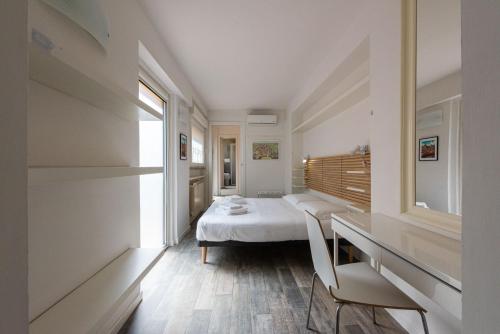 a bedroom with a bed and a desk and a window at Vettori Hideaway by MMega in Florence