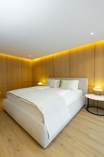 a large white bed in a room with wooden walls at Kö102 Prime Suites in Düsseldorf
