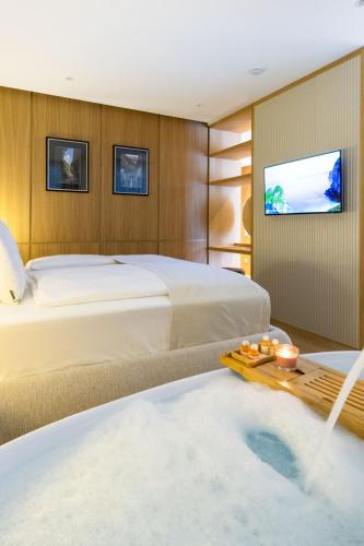 a hotel room with two beds and a tub at Kö102 Prime Suites in Düsseldorf