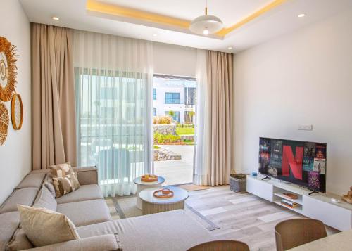a living room with a couch and a tv at Aqualina B3-2 by HolidayKeys in Kyrenia