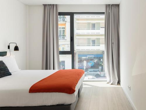 a bedroom with a bed and a large window at LSA Parque by Numa in Lisbon
