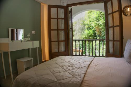 a bedroom with a bed and a large window at Villa Elizabeth Apartments in Ouranoupoli