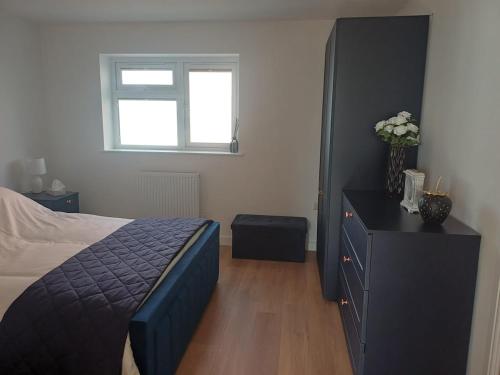 a bedroom with a bed and a dresser and a window at Ives End in Buxton