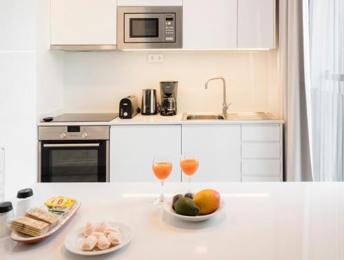 a kitchen with two glasses of wine and food on a counter at LSA Parque by Numa in Lisbon