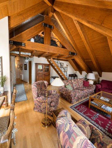 a living room with couches and a wooden ceiling at La Buhardilla - Benasque in Benasque