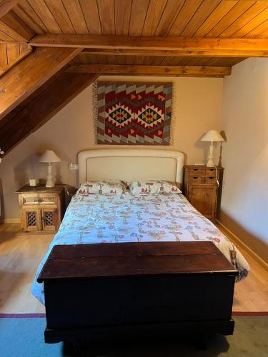 a bedroom with a bed in a room with wooden ceilings at La Buhardilla - Benasque in Benasque