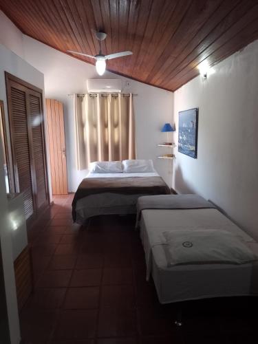a bedroom with two beds and a ceiling fan at RESONAMUH - Hostel in São Pedro da Aldeia