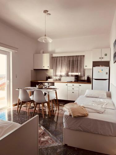 a kitchen with two beds and a table and chairs at Alkisti's seaside apartments in Pythagoreio