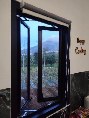 a window with a view of a mountain at Griya Alborz Dieng in Garung