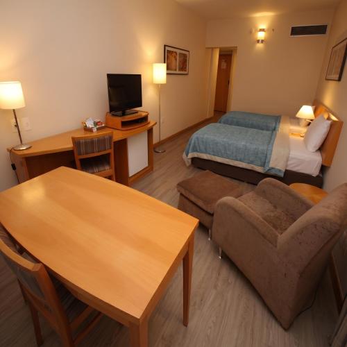 a hotel room with a bed and a living room at 1309 - Hotel & Residence Sol Alphaville Flat in Barueri