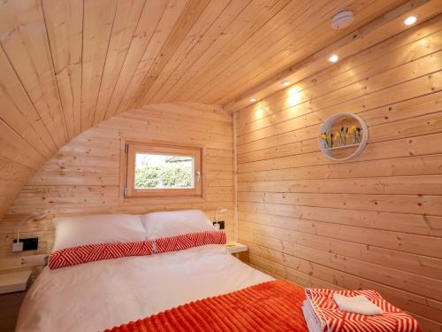 a bedroom with a bed in a wooden room at Little Oaks in Dingwall