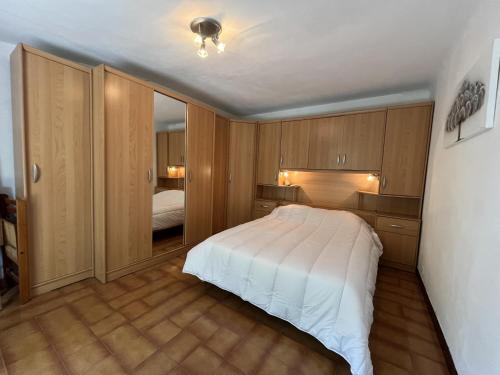 a bedroom with a white bed and wooden cabinets at Fréjus Plage - 5mins à pied des plages - Maisonette avec jardin, 4p, au calme absolu in Fréjus