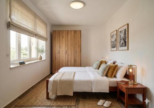 a bedroom with a large white bed and a window at Отрада in Utjeha