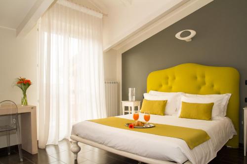 a bedroom with a large bed with a yellow headboard at Pepe's Home B&B in Nichelino
