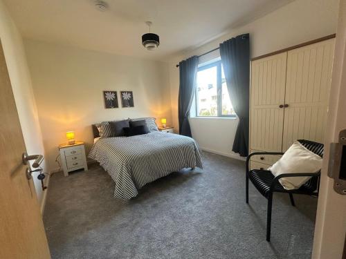 a bedroom with a bed and a window and a chair at House Sleeps 6 with Parking in Coad
