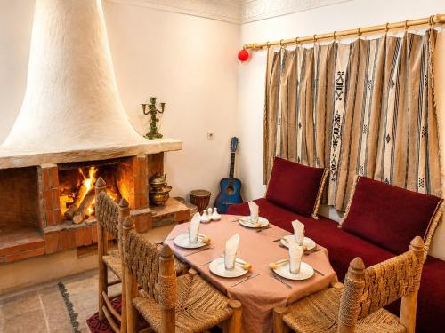 a living room with a table and a fireplace at Auberge des peupliers Café Restaurant in Akhendachou nʼAït Ouffi