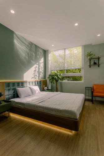 a bedroom with a large bed and a window at Mik Stay in Danang