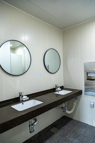 ein Badezimmer mit zwei Waschbecken und zwei Spiegeln in der Unterkunft Lazy Cube in Seoul