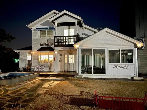 a large white house at night with at Daeboodo Prince Pension in Ansan