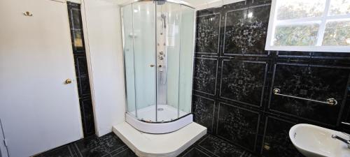 a bathroom with a shower and a toilet and a sink at Paralelo46 in Chile Chico