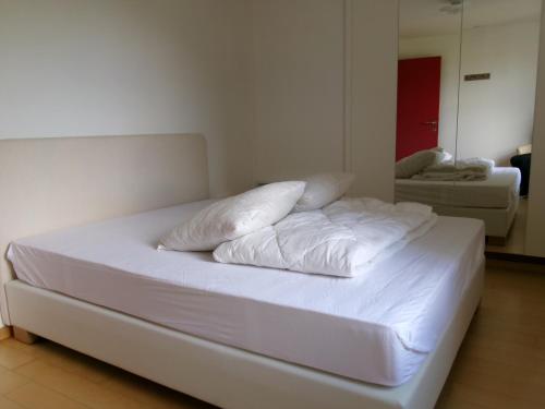 a white bed with pillows on it in a room at huisje Kraaiberg in Heuvelland