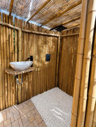 a bathroom with a sink in a bamboo wall at Bulle d'Alma - Bio climatique in Sotta