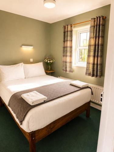 a bedroom with a large bed with a window at Wild Rowan Cottage - 2 Bedroom in Louisburgh