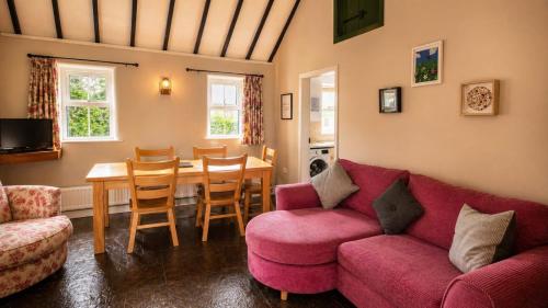 a living room with a red couch and a table at Wild Rowan Cottage - 2 Bedroom in Louisburgh