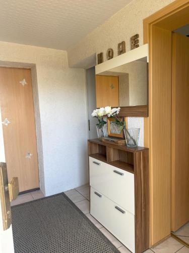 a closet with a dresser with a vase of flowers on it at Ferienhaus Jamshidi in Waren