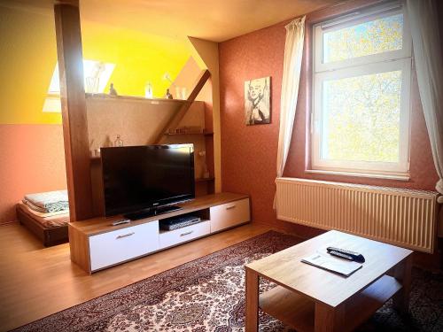a living room with a flat screen tv and a table at Ferienhaus Jamshidi in Waren