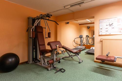 a gym with exercise equipment in a room at Hotel Miramonti Corvara in Corvara in Badia