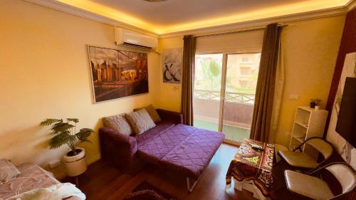 a living room with a purple couch and a window at Relaxing Studio-Malibu El Sokhna Resort in Ain Sokhna