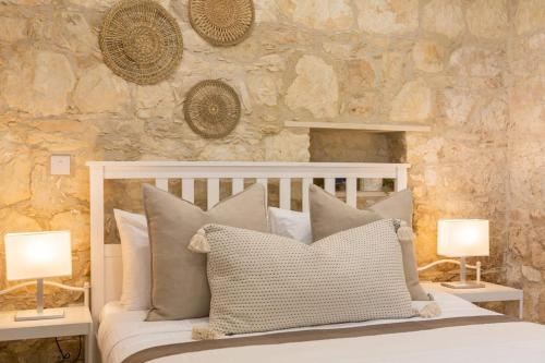 a bedroom with a bed with pillows and two lamps at Old Luxury Stone House Armou in Armu