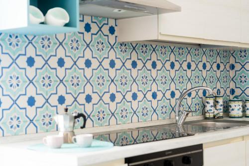 a kitchen with blue and white tiles on the wall at Mimì sul Mare in Massa Lubrense