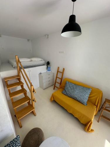 a living room with a bed and a stair case at Serenity Nest Serifos in Serifos Chora