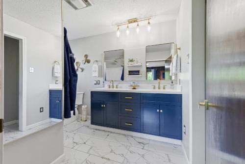 a bathroom with blue cabinets and a mirror at Hiwassee Lake Lodge - Private Mtn-Top Retreat - Lake Views - Sleeps 14 in Murphy