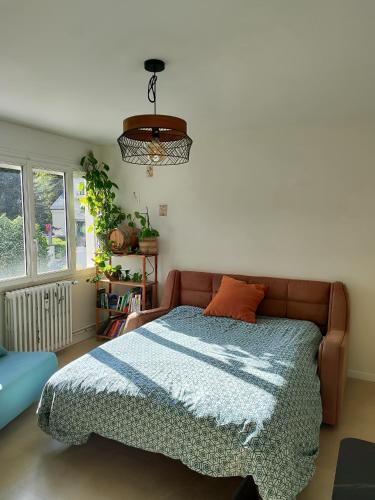 a bedroom with a bed with a blue blanket at Charmant T2 in Embrun