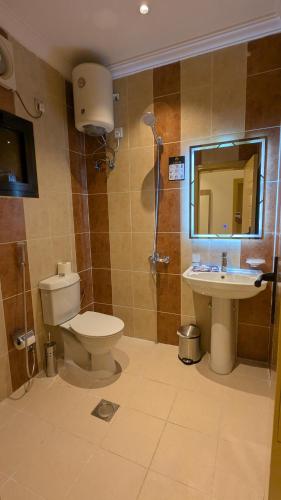 a bathroom with a toilet and a sink at أمكو للشقق المخدومة in Jeddah