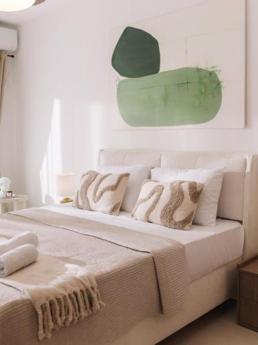 a white bedroom with two beds with pillows at NUA Apartments in Ulcinj