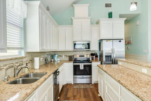 a kitchen with white cabinets and a sink at Steps from the Jetty & Beach in Surfside Beach