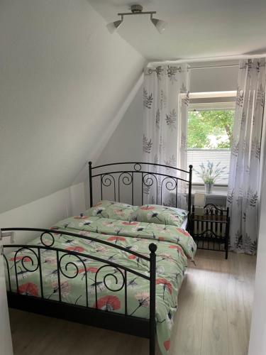 a bedroom with a bed and a window with curtains at Vakantiewoning MaRa in Neuenhaus