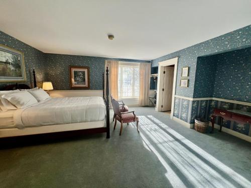 a bedroom with a bed and a chair in it at Strawtown Inn & Events in Pella