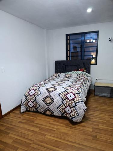 a bedroom with a bed with a quilt on it at Huset södra Quito in Quito