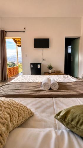 a bedroom with a large bed with towels on it at Pousada Serra do Encanto in Delfinópolis