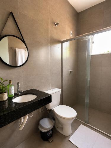 a bathroom with a toilet and a sink and a shower at Pousada Serra do Encanto in Delfinópolis