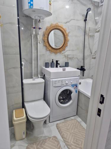 a bathroom with a washing machine and a sink at Elegant Home Apart in Karagandy