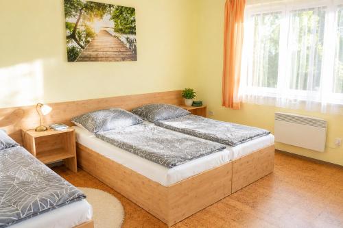 a bedroom with two beds and a picture on the wall at Chata Bystřička in Velká Lhota