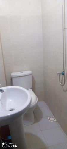 a bathroom with a white toilet and a sink at Chambre d'hôtes à louer in Pikine